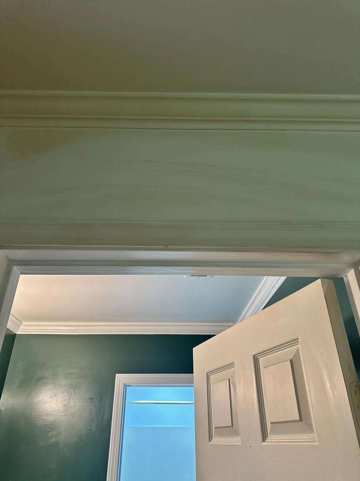 Yellow tobacco residue above a doorway before wall cleaning